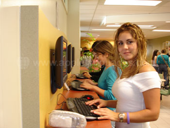Une étudiante utilisant un ordinateur dans le salon-internet